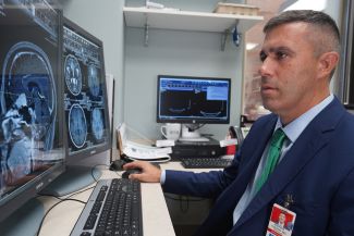 Dr. Fabiano looking at a scan of the brain and spine.