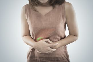 A woman clutches her midsection with the intestinal system highlighted to indicate the gallbladder. 