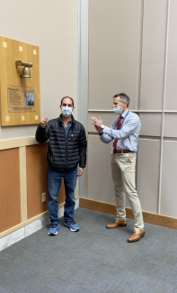 Dan DiClemente rings the Victory Bell with Dr. Schwaab standing by