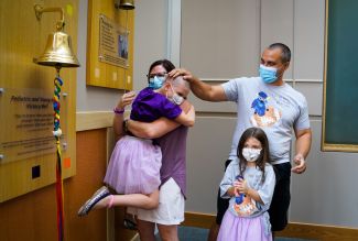 Peds patient Keeley Noworyta embraces her family after ringing the Victory Bell 2022