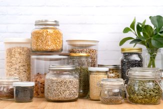 Glass jars full of whole grains, nuts and seeds, fiber - stock