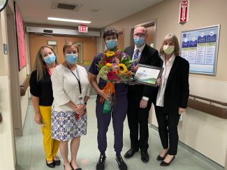 Tyler Russ, center, received flowers and a framed certificate in recognition of being named Nurse of the Month for September. 