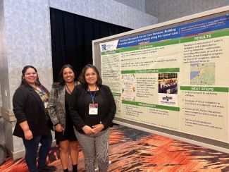 Three women in the CICR patient navigator program stand in front of their poster during a conference in Tucson. 