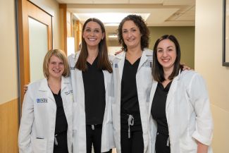 Allison Czwojdak, Lauren Snyder, Lindsay Wachowiak and Sarah Crance of the speech-language pathology team stand together in a hospital hallway.