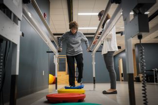 Mary Ebert works on her balance with Physical Therapist, Carolyn Miller.