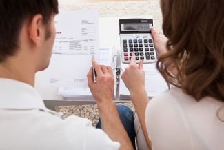 Two people reviewing their bills and using a calculator