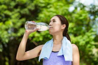 Young person drinking water while excercising