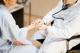 Patient holding hands with healthcare professional