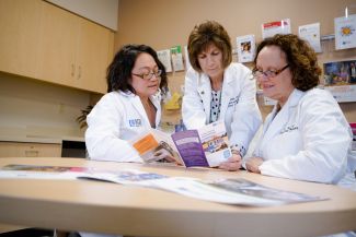 Three Roswell Park professionals review cancer screening publications.