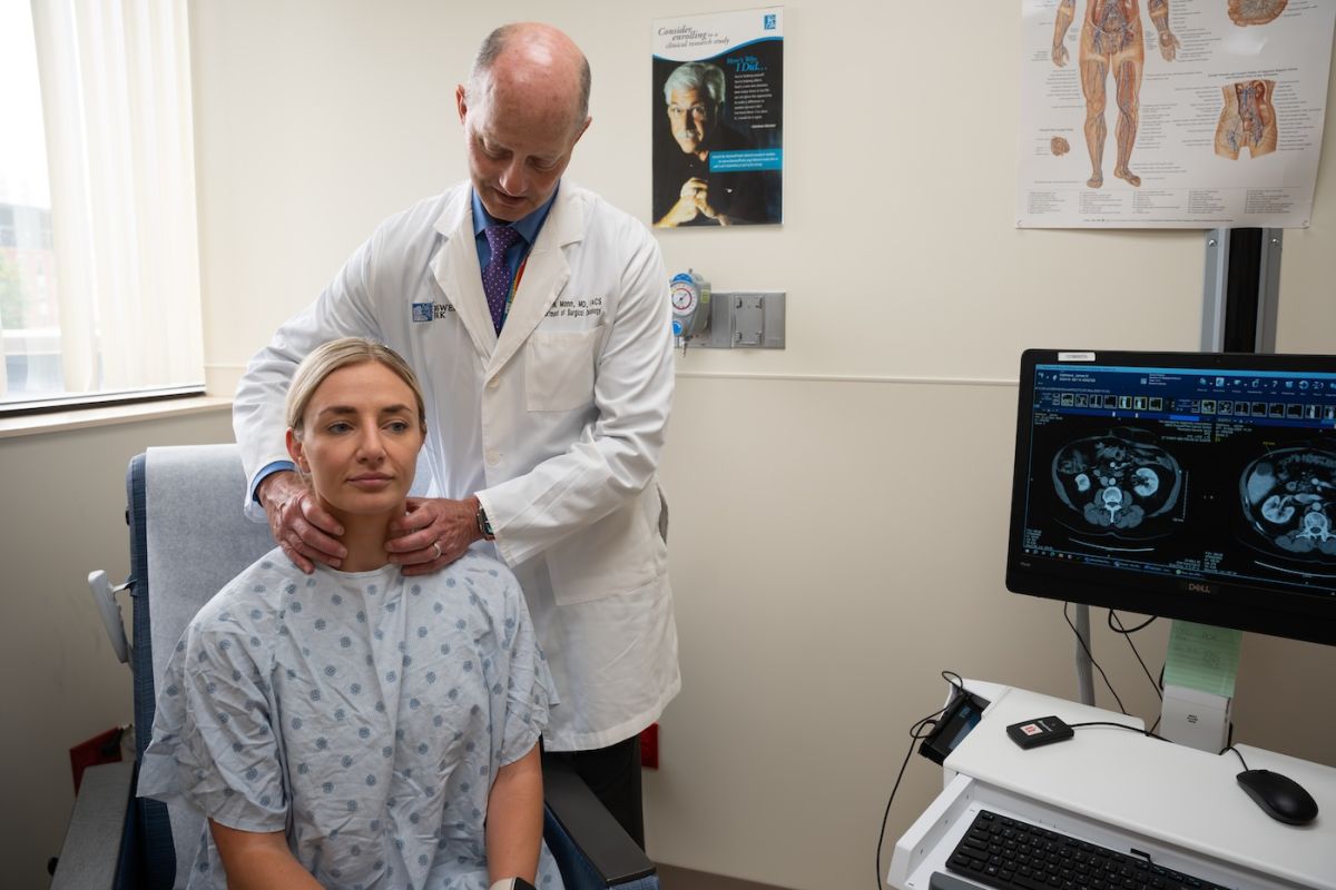 Dr. Gary Mann feels a patient's lymph nodes